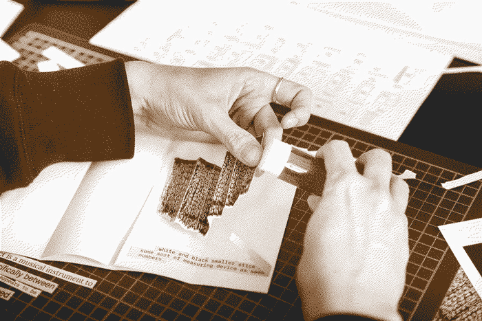 A close up of a participant pasting a photo with a gluestick into a zine