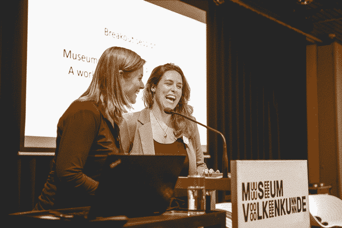A pair of participants speaking through a microphone on stage