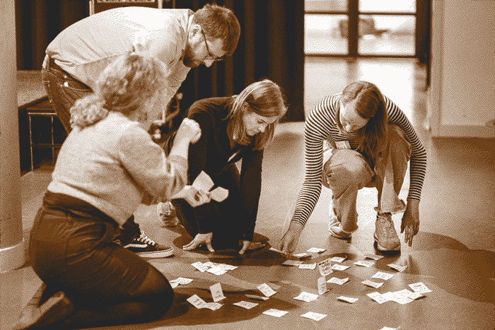 Four participants crouching down on the floor with an assortment of post-its